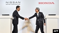 Chủ tịch kiêm Giám đốc điều hành Nissan, Makoto Uchida (trái), và Chủ tịch kiêm Giám đốc điều hành Honda, Toshihiro Mibe, bắt tay nhau trước một cuộc họp báo ở Tokyo ngày 1/8/2024.