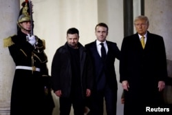 French President Emmanuel Macron accompanies U.S. President-elect Donald Trump and Ukraine's President Volodymyr Zelenskiy as they leave after a trilateral meeting at the Elysee Palace in Paris as part of ceremonies to mark the reopening of the Notre-Dame de Paris Cathedral, five-and-a-half years after a fire ravaged the Gothic masterpiece, in Paris, France, December 7, 2024. 